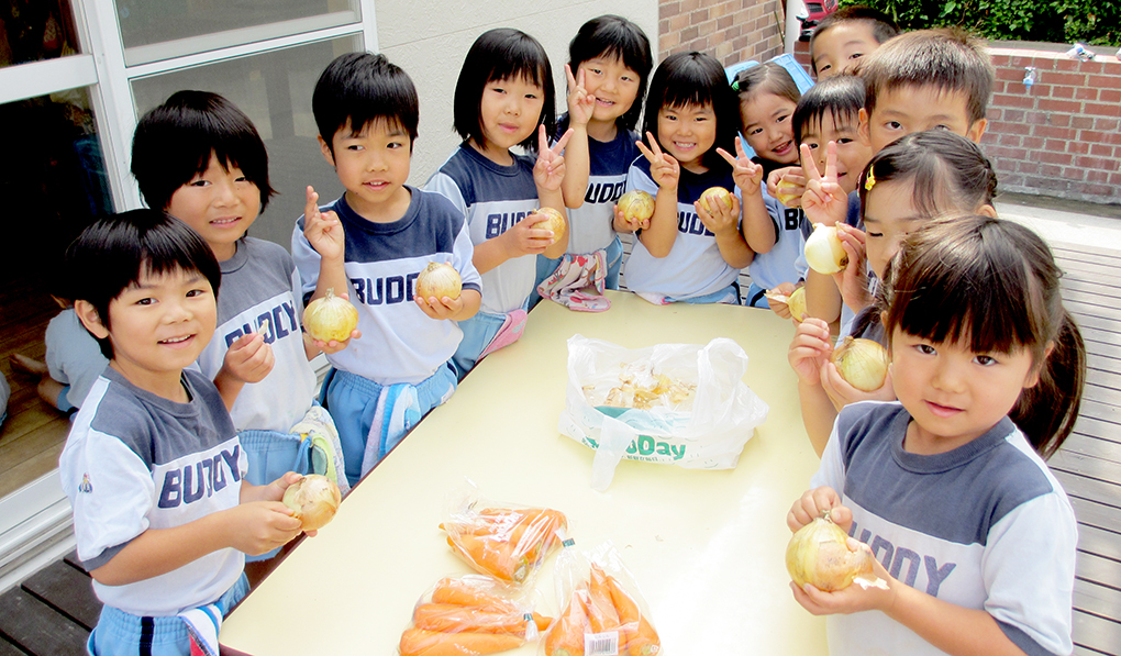 玉ねぎをむく園児たち